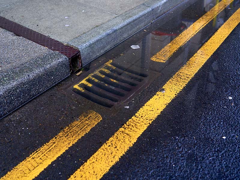 A waterlogged on a blocked drainage on street after the rain