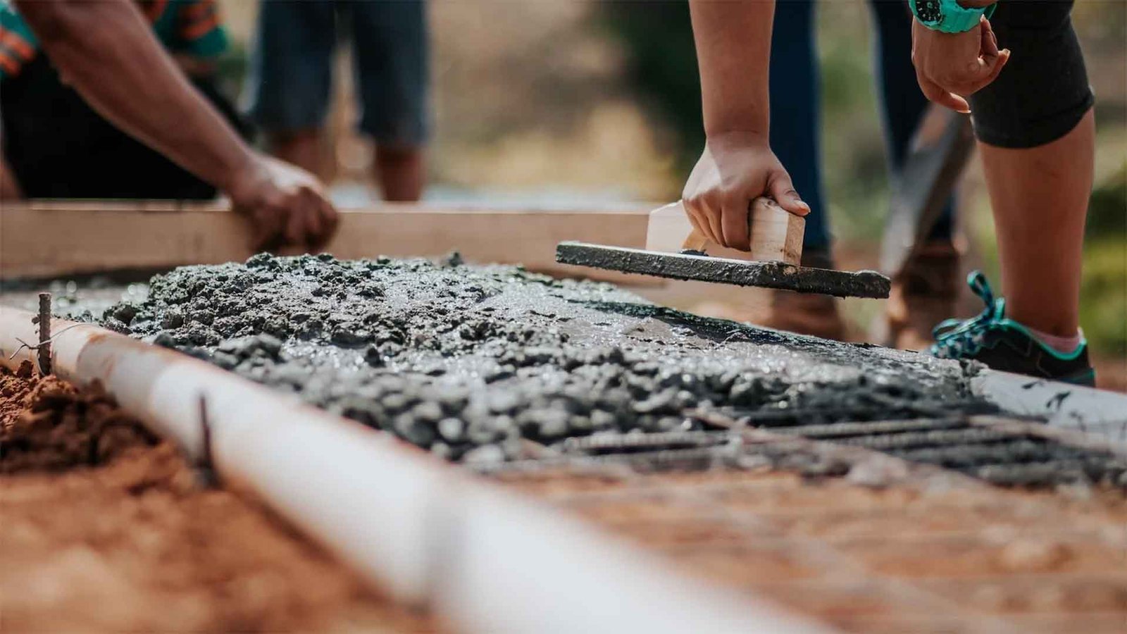 A worker smoothing concrete